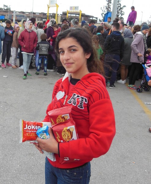 In the background, Arabic-speaking refugees vie for snacks tossed from a van by an informal network of Samaritans from central Athens. This girl, who spoke no English, scored her cookies and juice box early, and insisted on documenting her success in a photo. March 18, 2016 