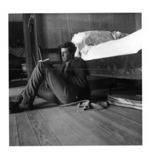 Willie Graham on the floor of his bedroom, reading. Guion, Texas. Early 1900.
