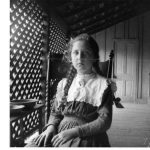 Young girl, with braids, on a veranda. Moorefield, Arkansas. 1899- 1900.