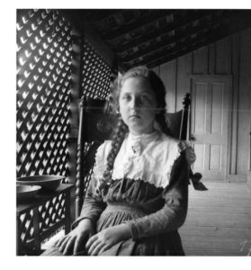 Young girl, with braids, on a veranda. Moorefield, Arkansas. 1899- 1900.