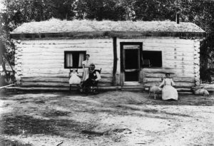 Evelyn Cameron. Family in front of their log house. Montana. 1902.