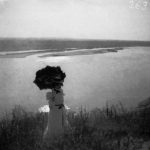 Woman with umbrella on high bank above the Mississippi near St. Louis. 1900.