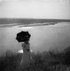 Woman with umbrella on high bank above the Mississippi near St. Louis. 1900.